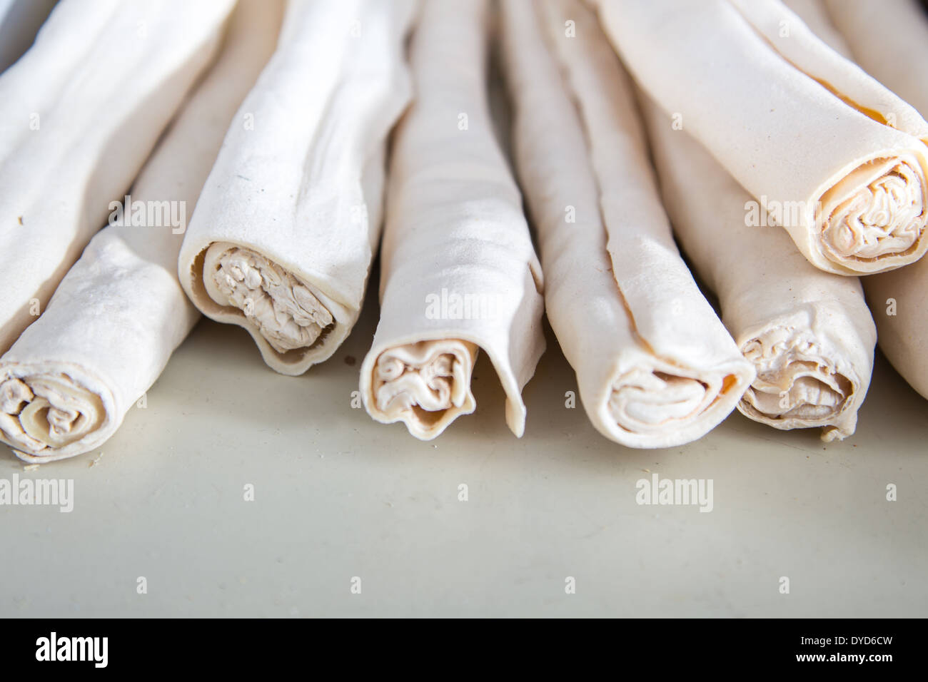 a stack of rolled rawhide chews on a shelf at the pet store Stock Photo