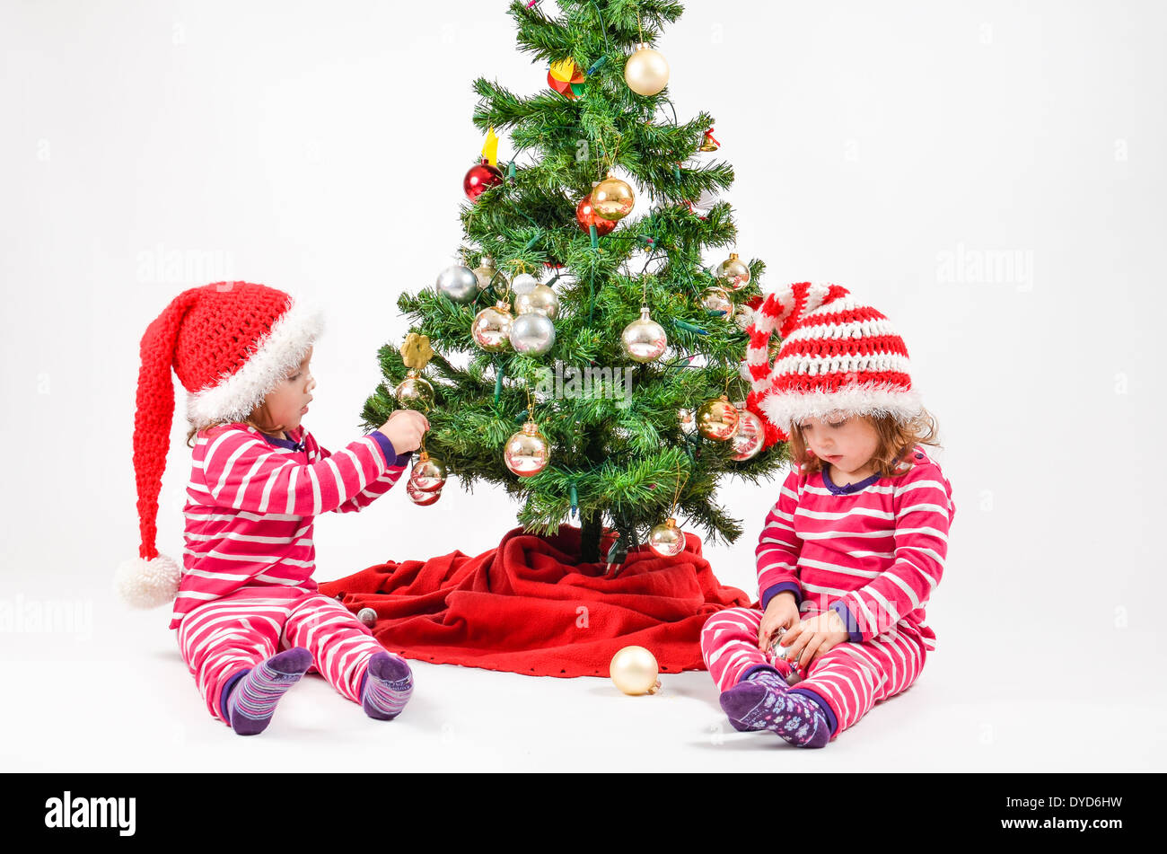 Twin babies decorating a Christmas Tree Stock Photo Alamy
