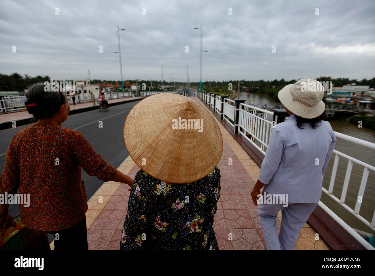 Women walk on the bridge in Ben Tre province, Vietnam Stock Photo