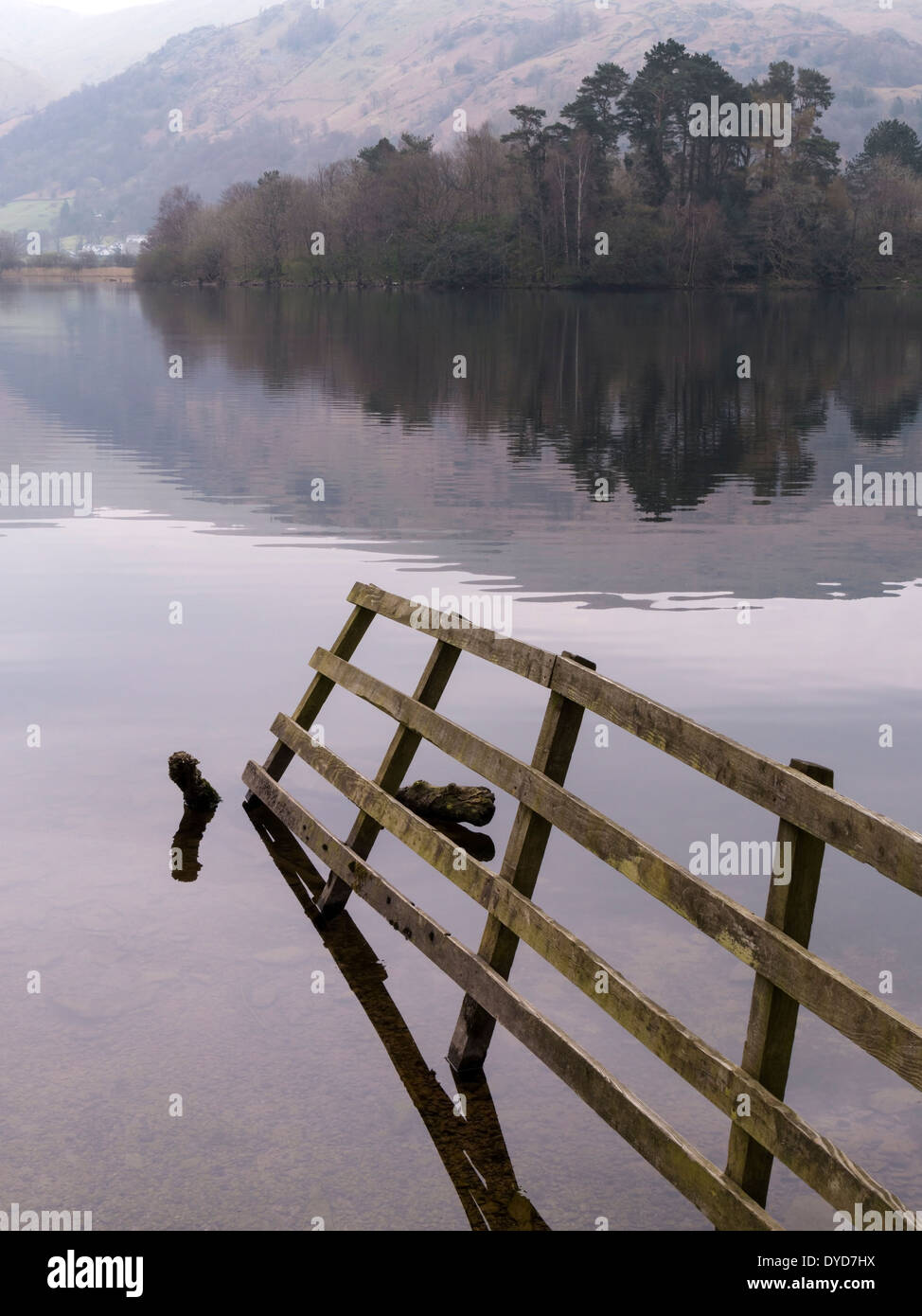 Wooden fence in still waters of Lake Grasmere, English Lake District, Cumbria, England, UK Stock Photo