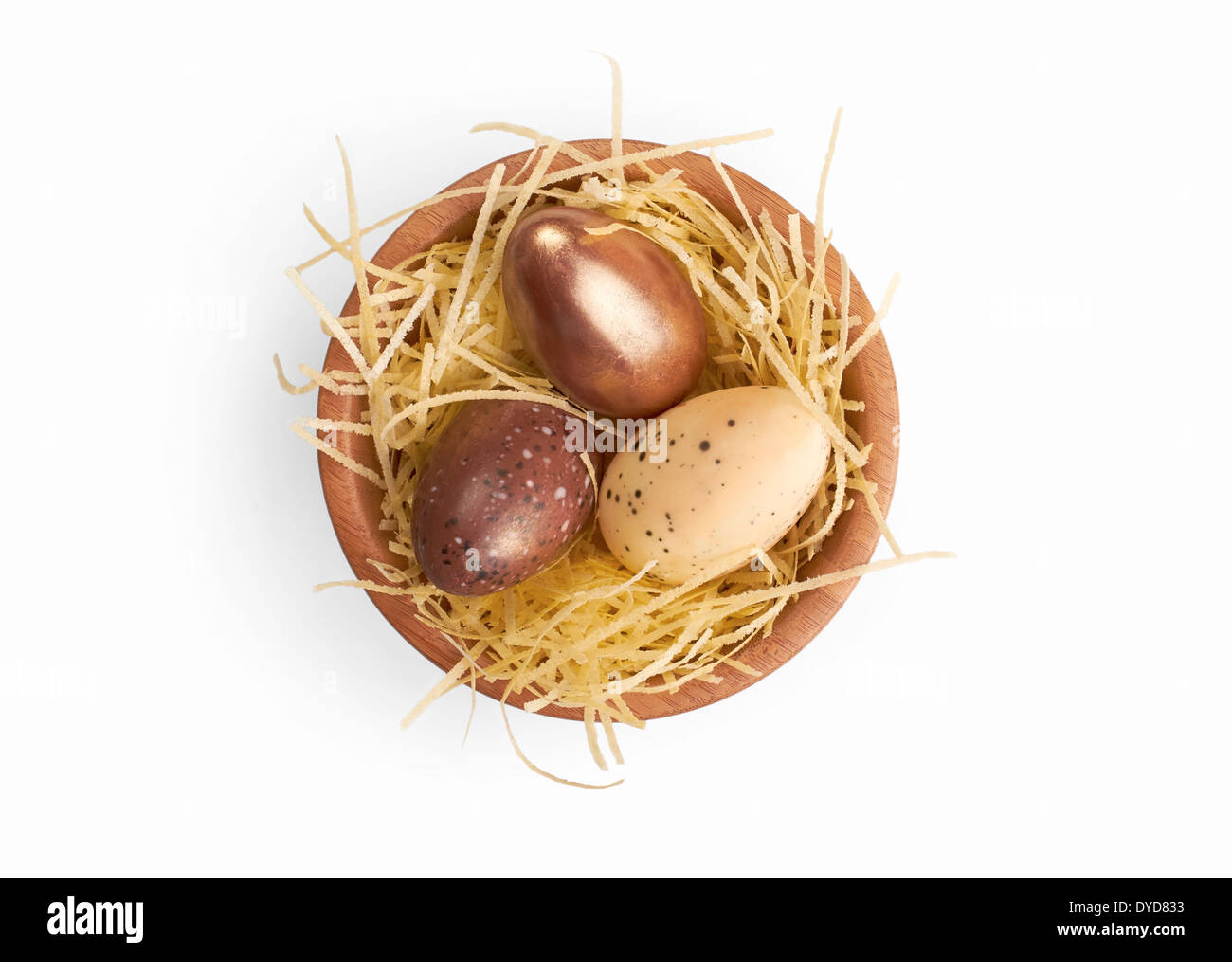 Mixed Easter eggs in a wooden bowl isolated on a white background. Stock Photo