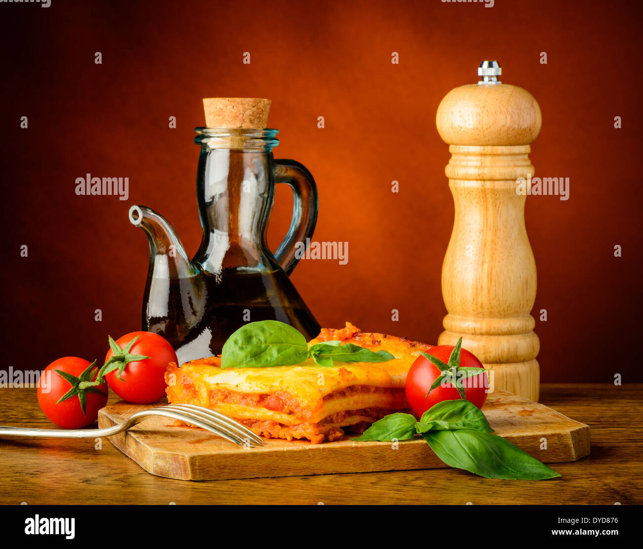 traditional dinner with lasagna bolognese, olive oil and pepper mill Stock Photo