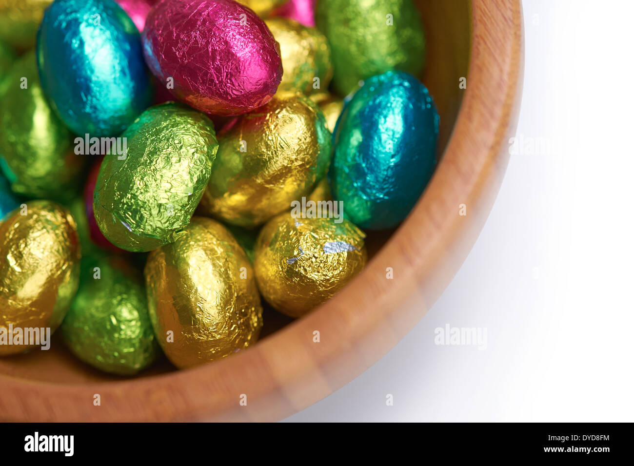 Colouful foil wrapped easter eggs in a bowl on a white isolated background. Stock Photo