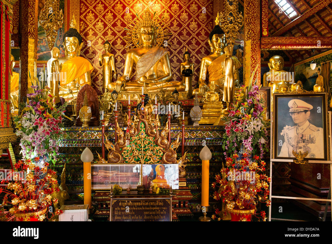 Golden Buddha statues and a picture of King Bhumibol Adulyadej in Wat Phrah Singh Temple, Chiang Rai, Chiang Rai province Stock Photo