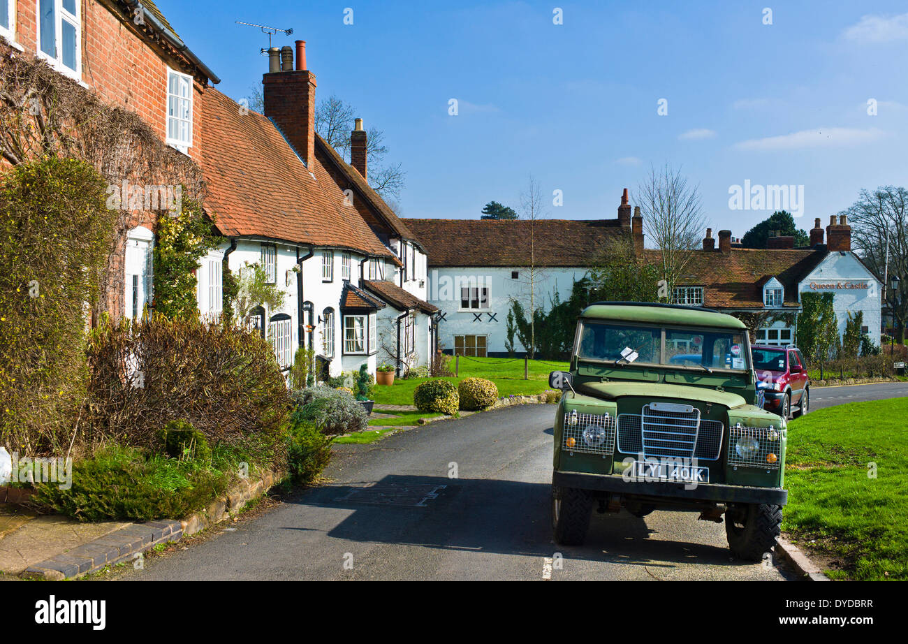 An old Land Rover outside ancient cottages in the historic town of Kenilworth in the green heart of Warwickshire. Stock Photo