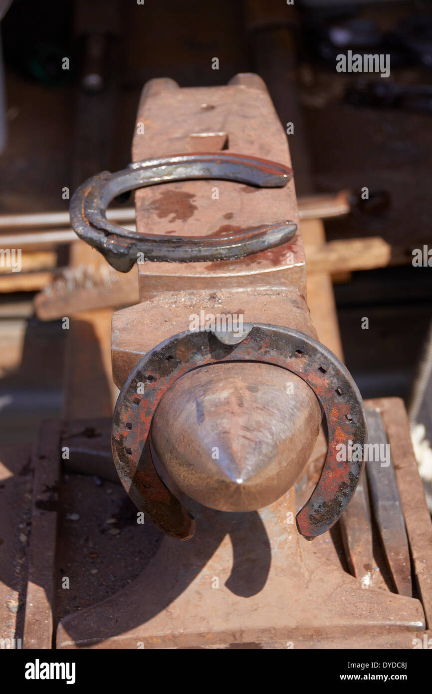 A portable anvil with horseshoes awaiting fitting. Stock Photo