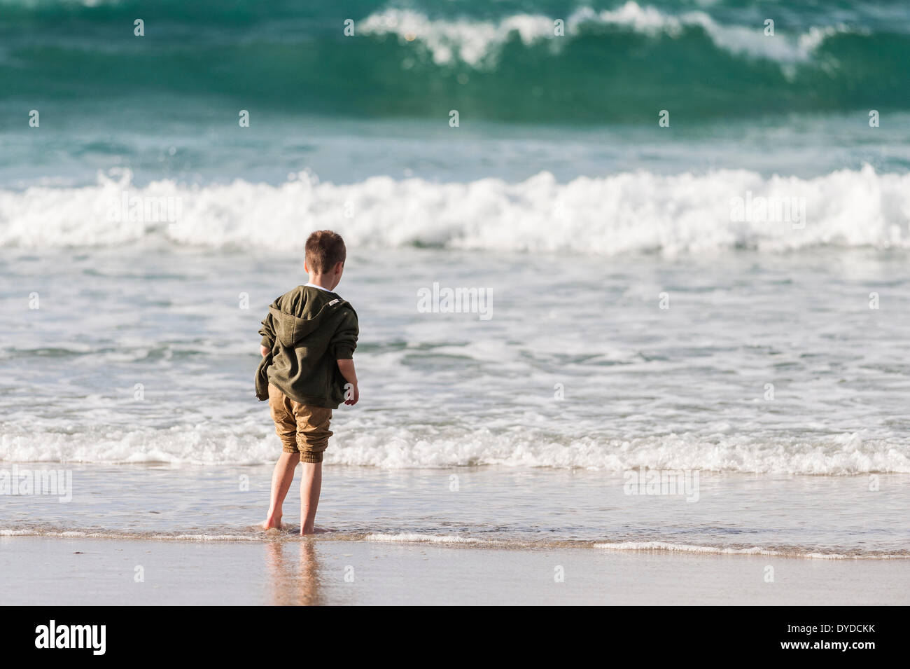 A young boy paddling in the sea in Cornwall. Stock Photo
