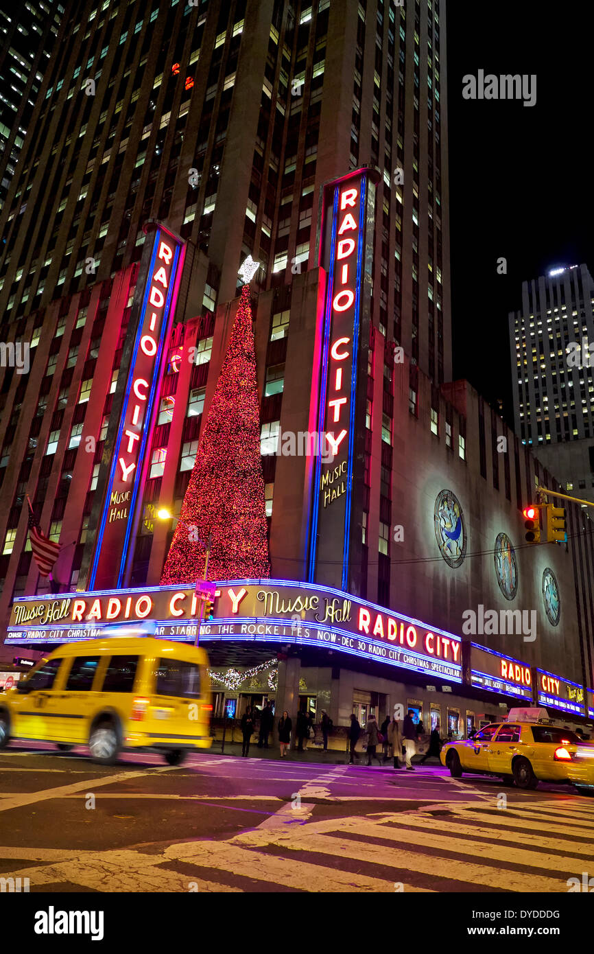 Cabs zoom by Radio City Music Hall. Stock Photo