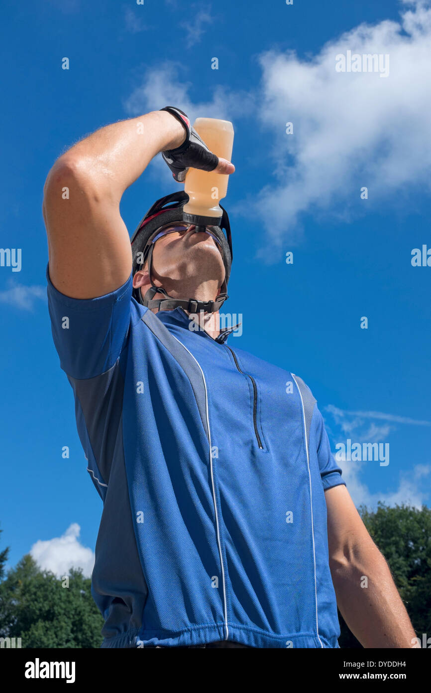 Male cyclist drinking from a water bottle. Stock Photo