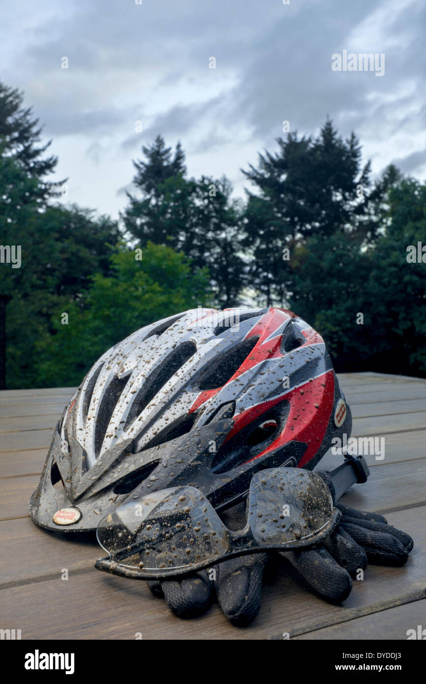 Mud spattered cycle helmet with glasses and gloves. Stock Photo