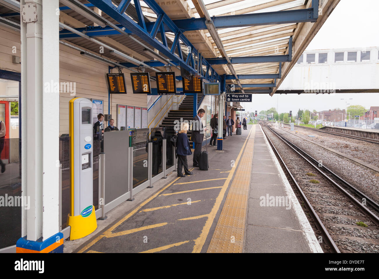 Passengers waiting for a train on a station platform. Stock Photo