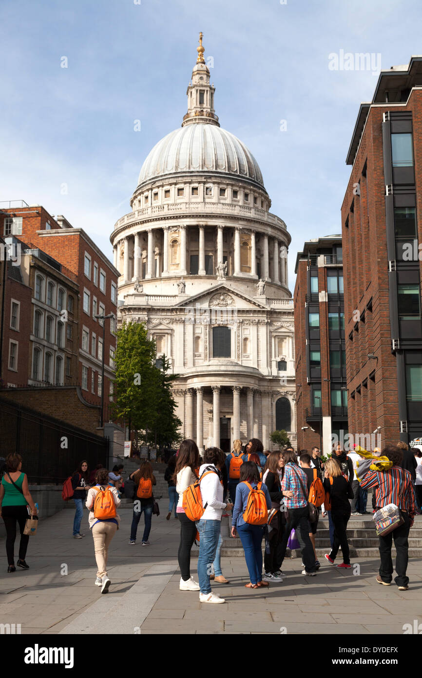 Group of tourists with orange backpacks looking at the South Facade of St Paul's Cathedral and dome. Stock Photo