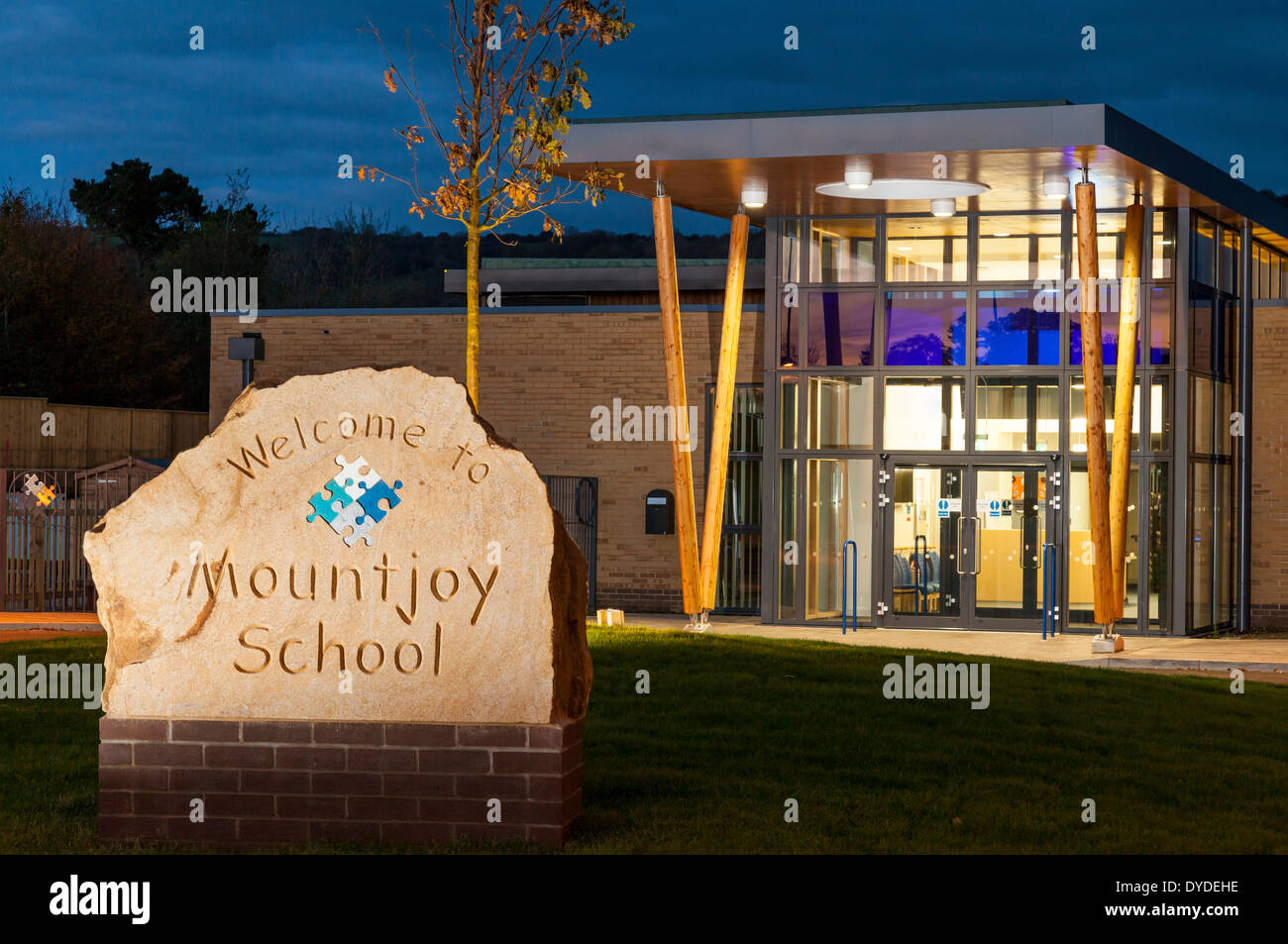 Carved school name on stone at the main entrance to Mountjoy School in Beaminister at dusk. Stock Photo