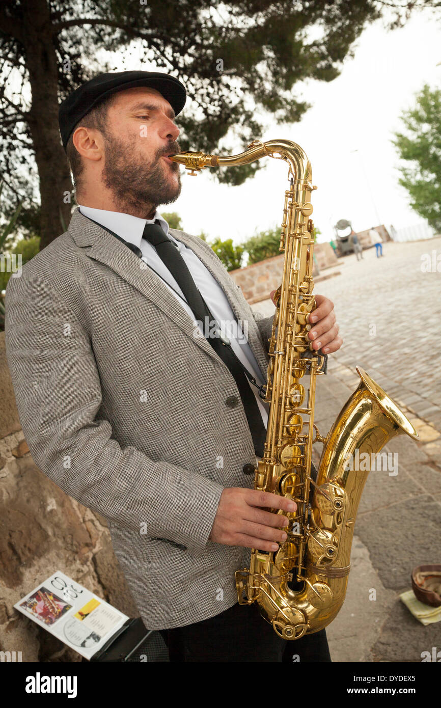 Male busker playing saxophone. Stock Photo