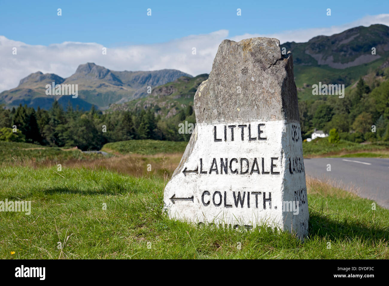 Stone road sign near Elterwater with Langdale Pikes in the background. Stock Photo