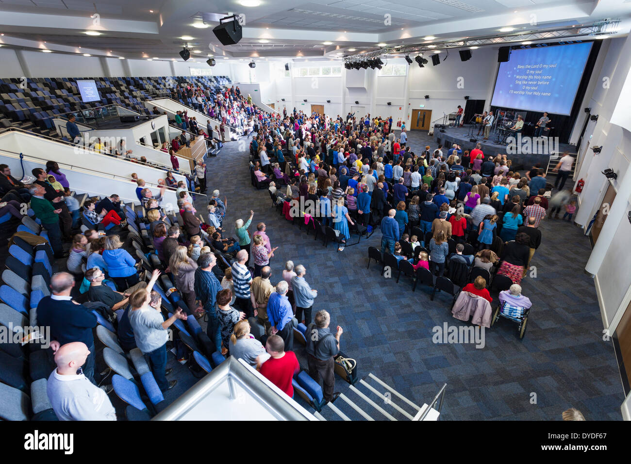 Congregation participating in contemporary worship music during Sunday Service inside the large modern Kings Community Church. Stock Photo