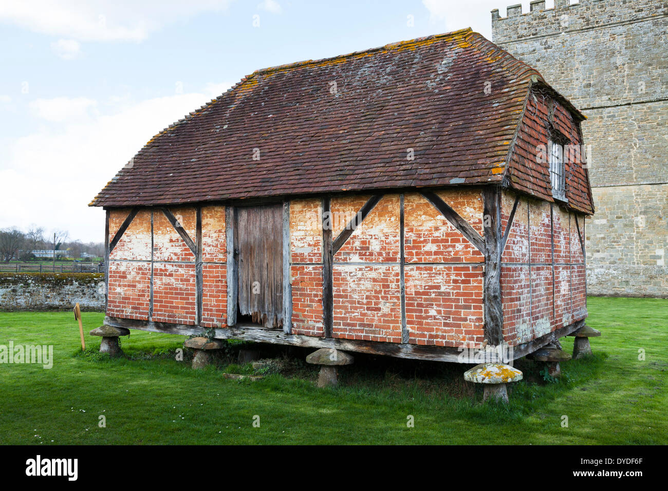 Historic granary barn set on mushroom shaped straddle stone at Cowdray in Midhurst. Stock Photo