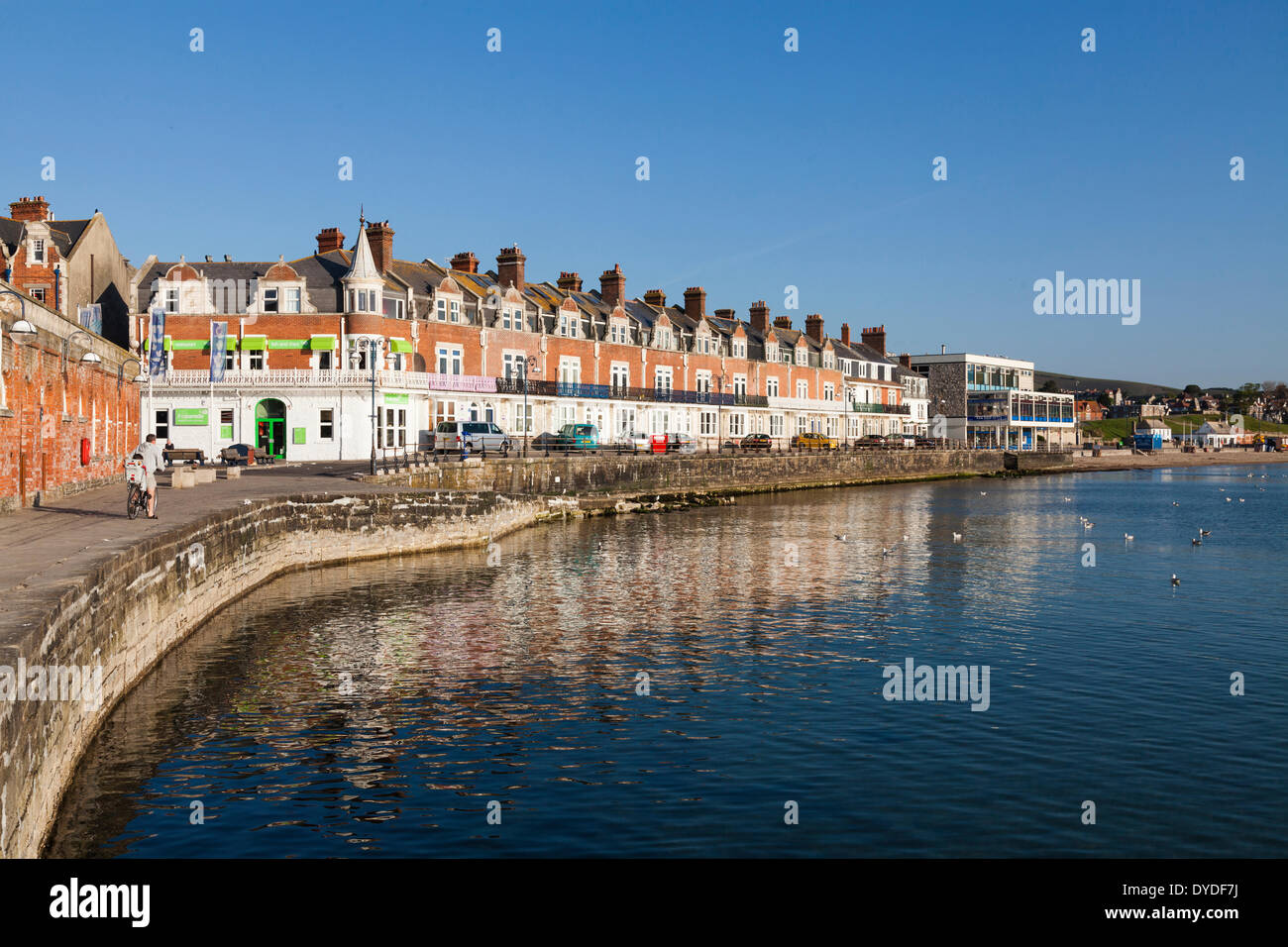Promenade and sea wall at Swanage in the early morning sunshine. Stock Photo