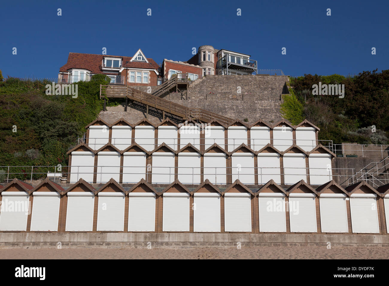 Stack of three tiers of white doored beach huts at Swanage. Stock Photo