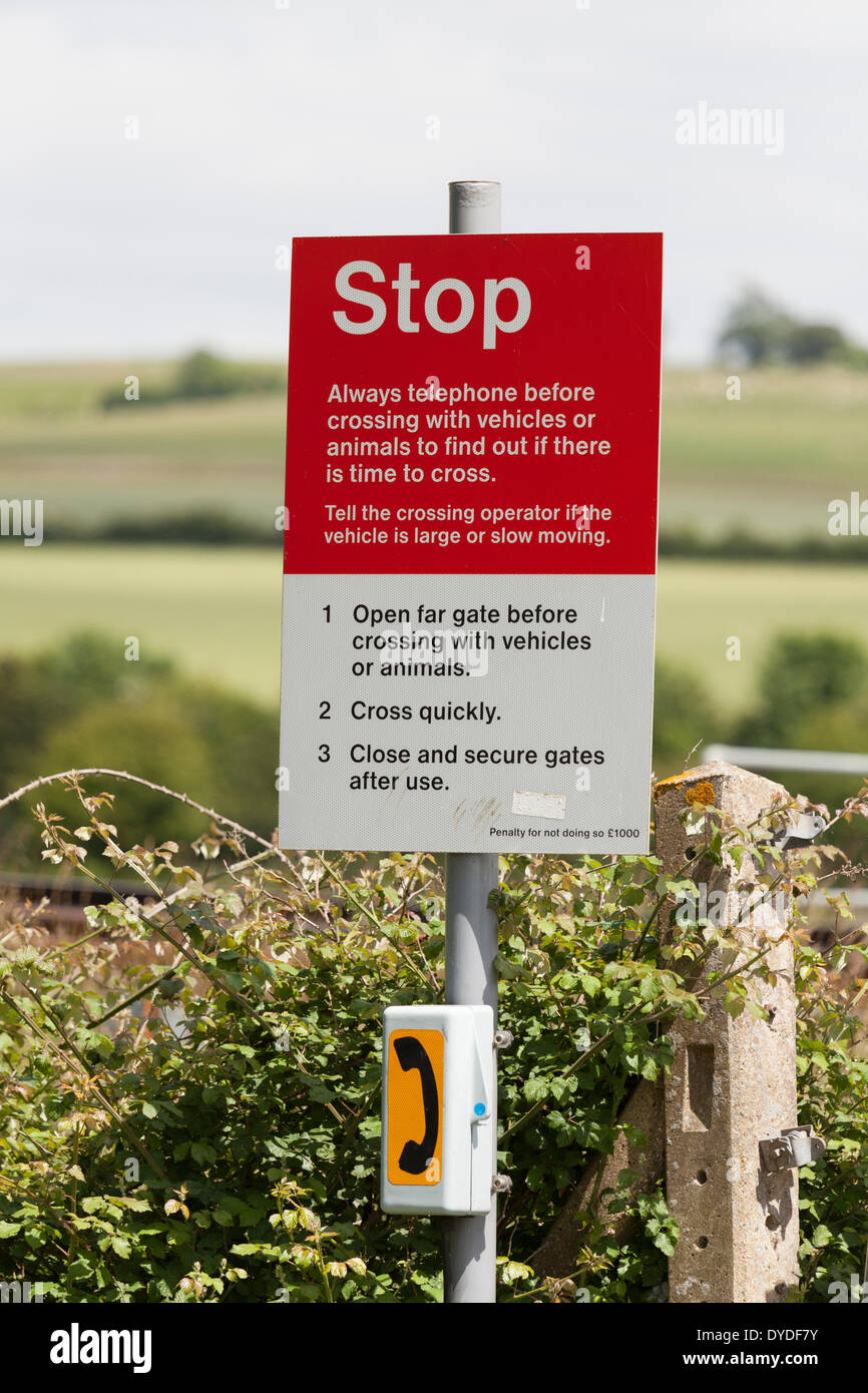Farm railway crossing warning sign and access telephone. Stock Photo