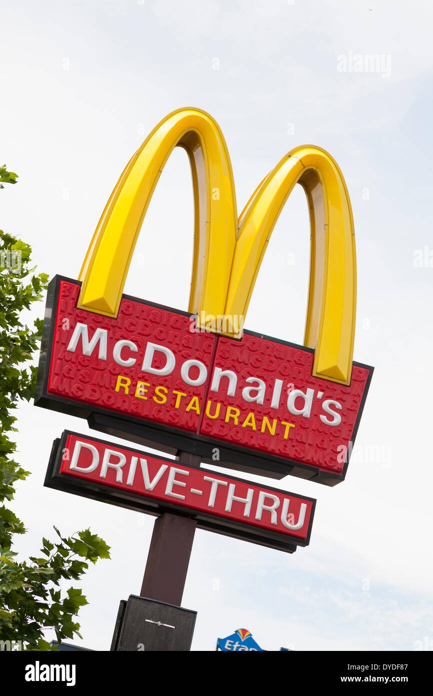 McDonald's sign and company logo on post with drive-thru sign at West Quay in Southampton. Stock Photo