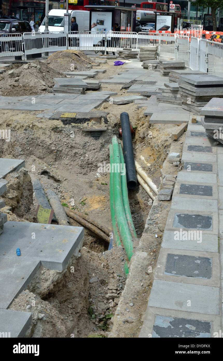 Exposed pipes under a new pavement. Stock Photo