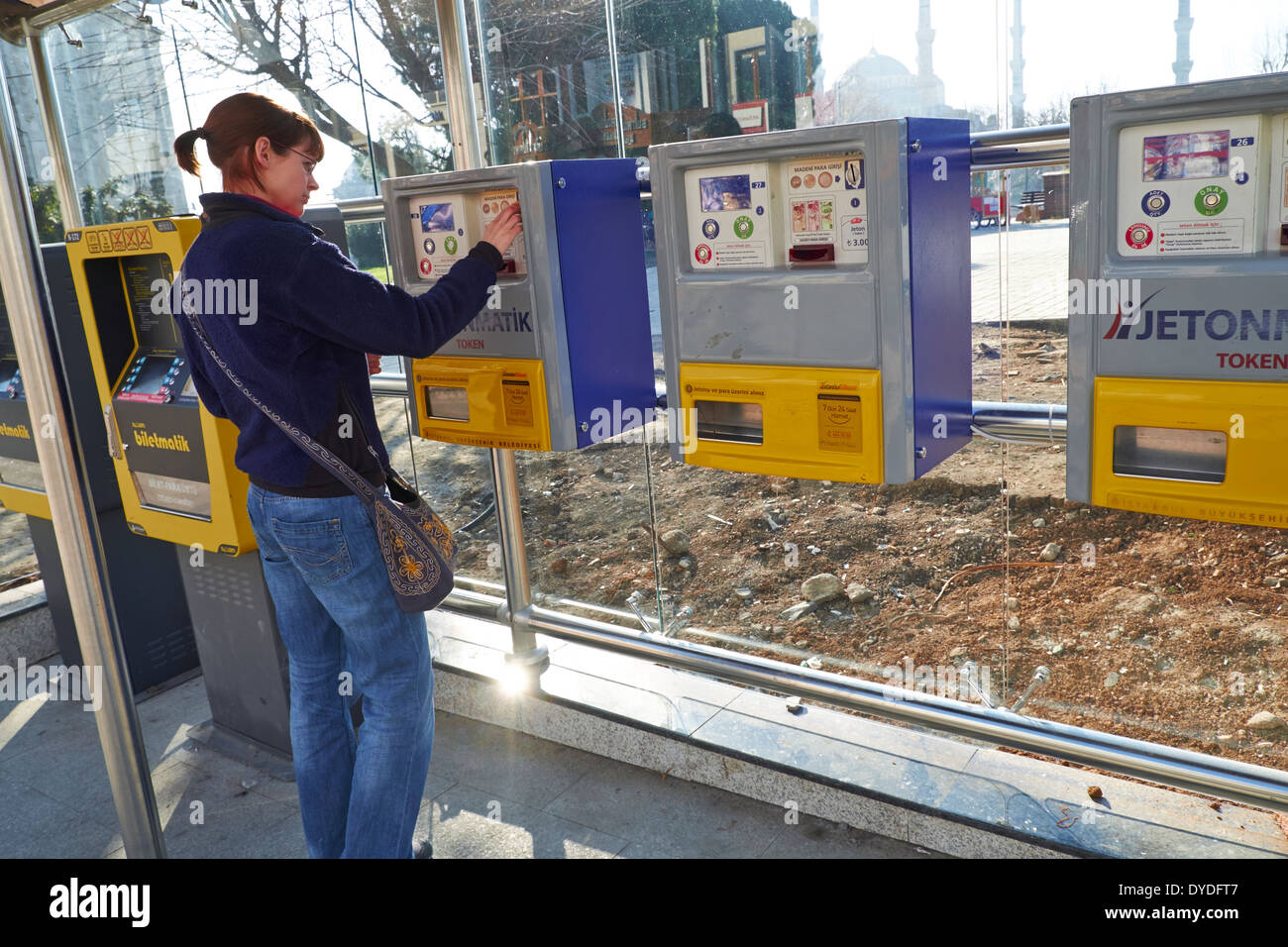 A woman buying a ticket from a machine for a tram in Istanbul, Turkey. Stock Photo