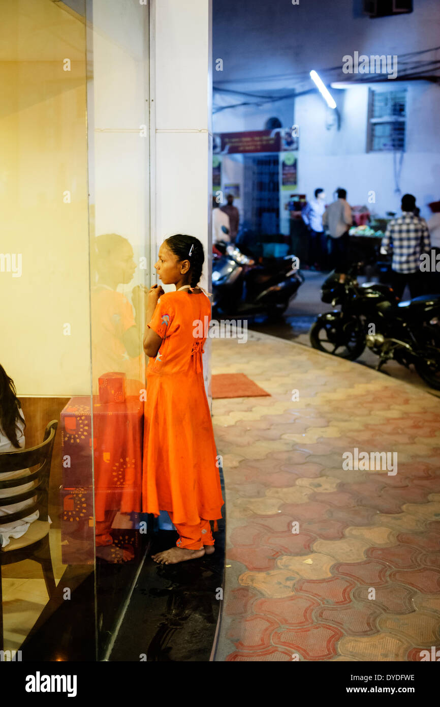 A poor street kid staring longingly into a coffee shop in Amritsar. Stock Photo