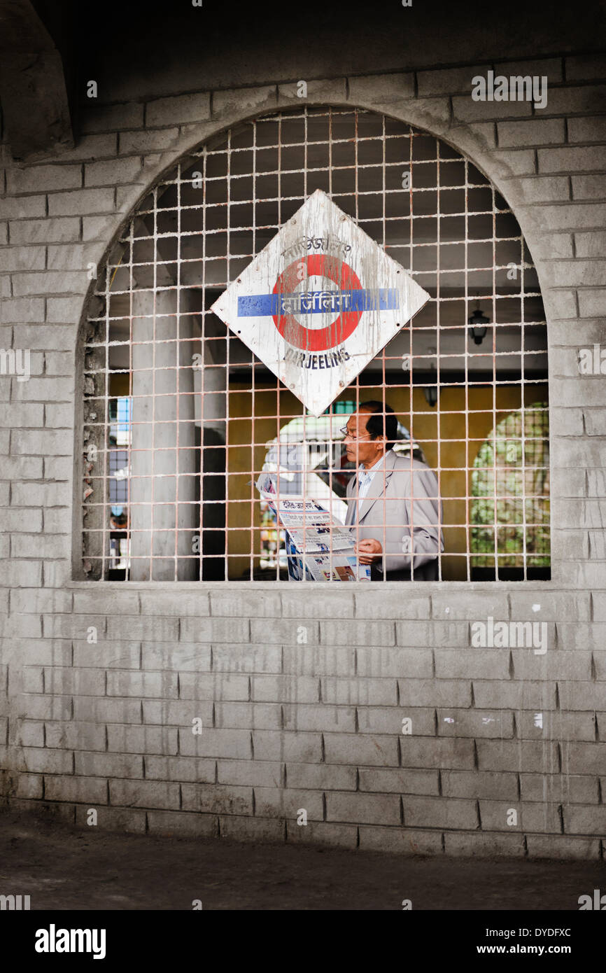 A man reading the paper at Darjeeling railway station. Stock Photo