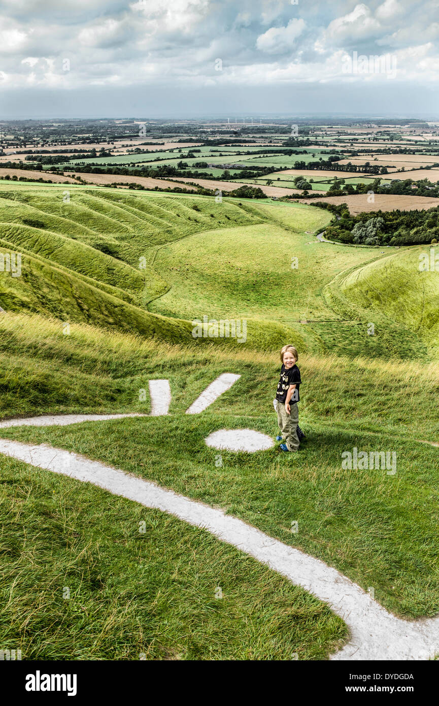 A young boy explores Uffington White Horse which is a prehistoric chalk