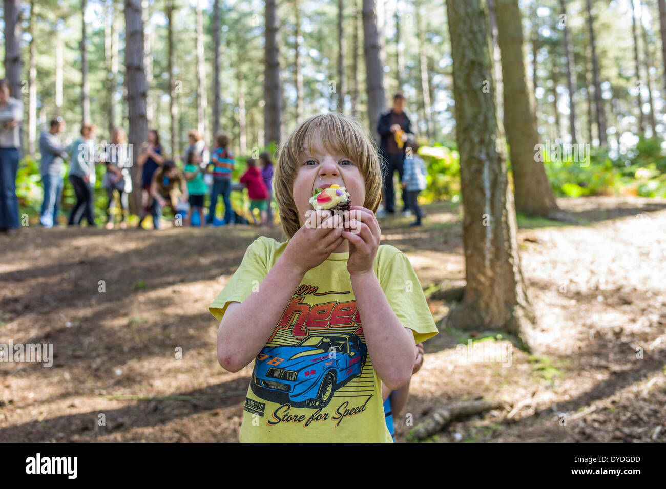 A young boy eating a cake in the woods. Stock Photo