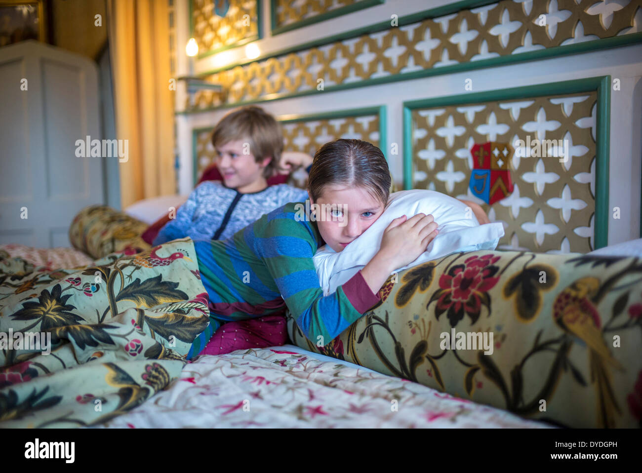Two boys in onesies in the biggest hotel bed in Europe at Thornbury Castle. Stock Photo