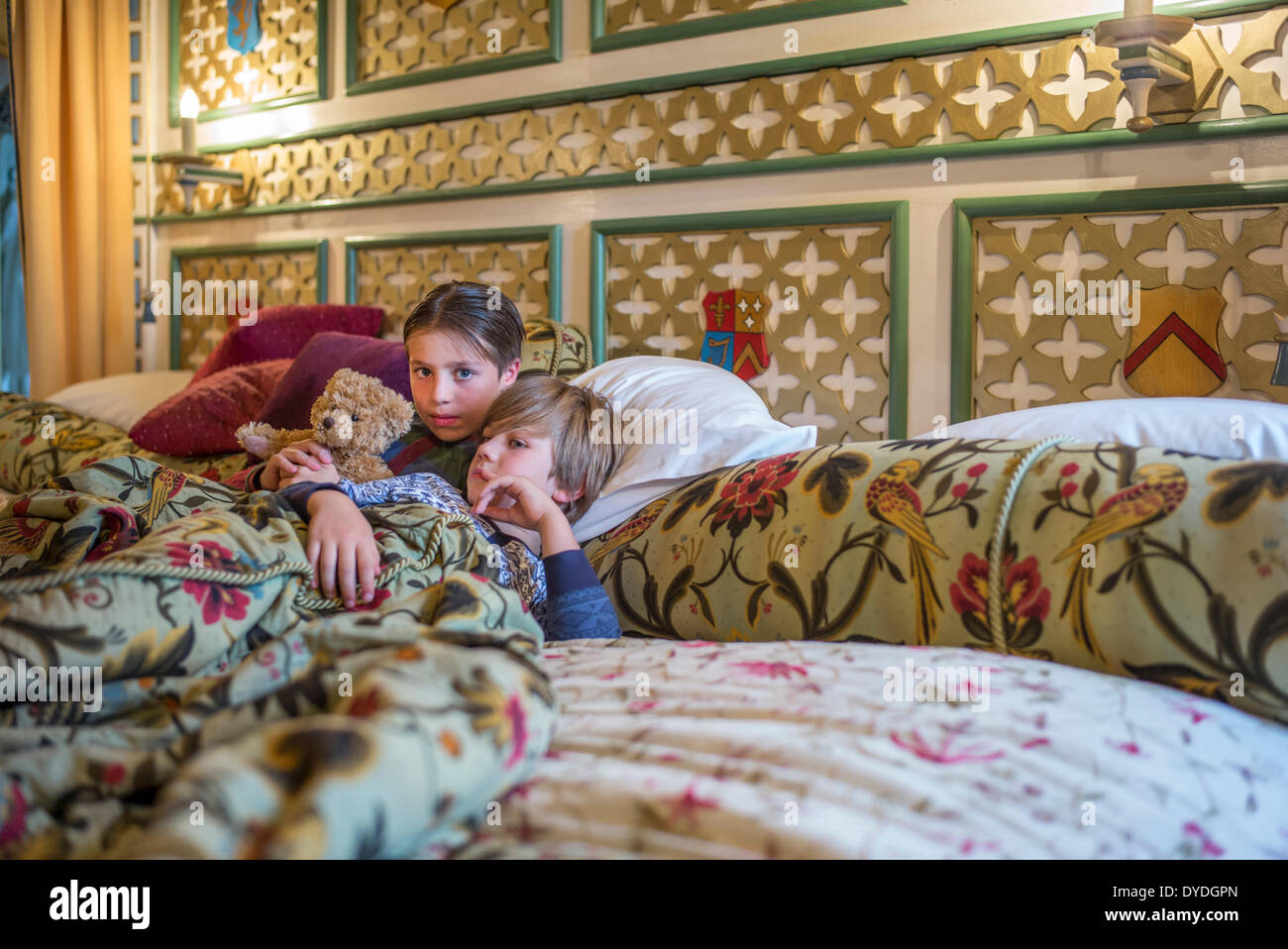 Two boys  in onesies in the biggest hotel bed in Europe at Thornbury Castle. Stock Photo