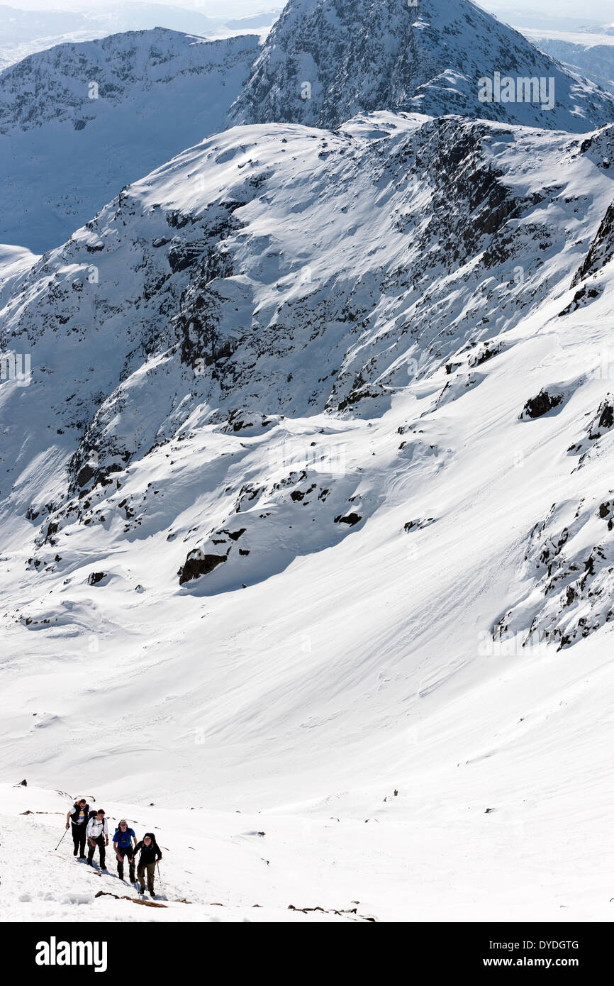 A group of people climbs the snowy Pyg Track in the Snowdonia National Park. Stock Photo