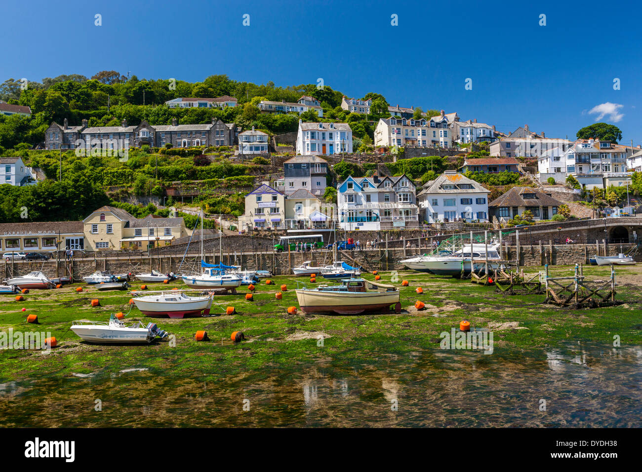 Fishing boats and sailing yachts moored in Looe harbour during low tide. Stock Photo