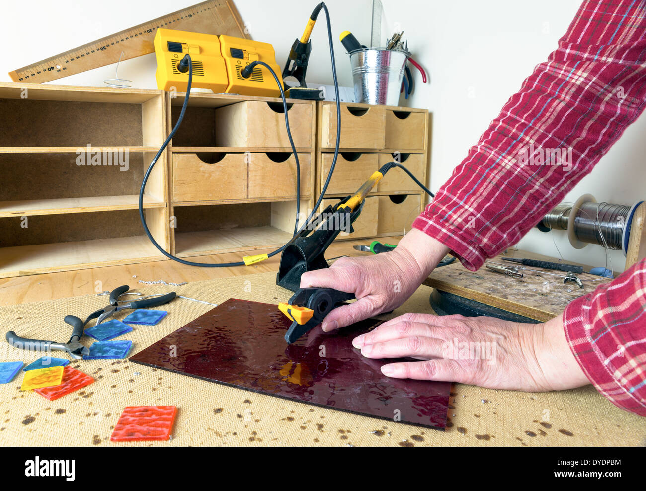 Artist cutting sheets of stained glass Stock Photo Alamy