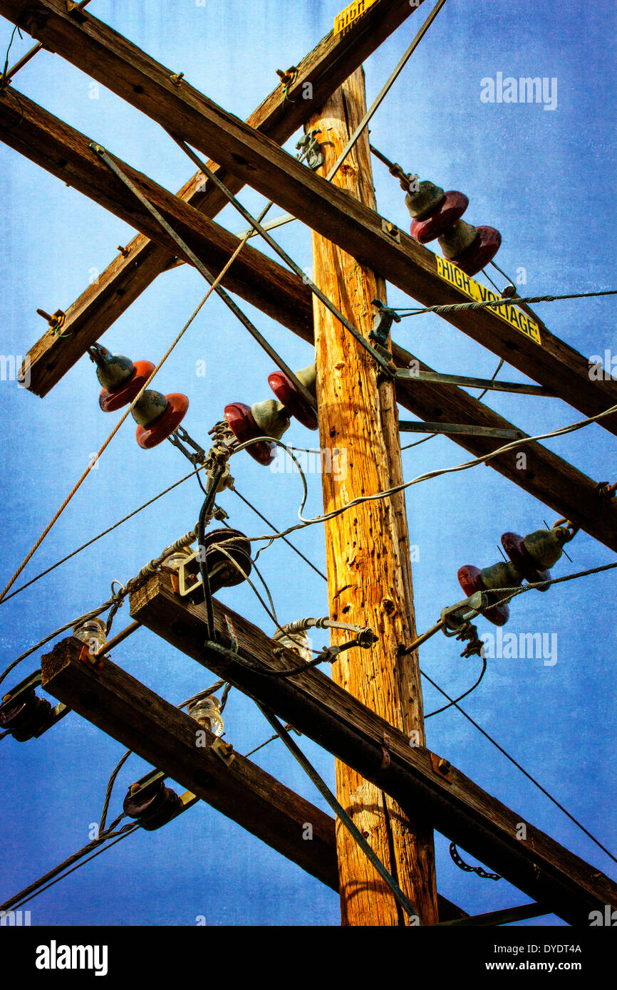 Power cables attached to telephone pole with High Voltage warning sign