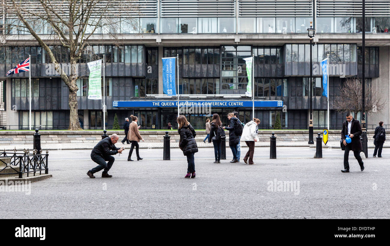 Queen Elizabeth ll conference centre and tourists taking photographs, London, UK Stock Photo