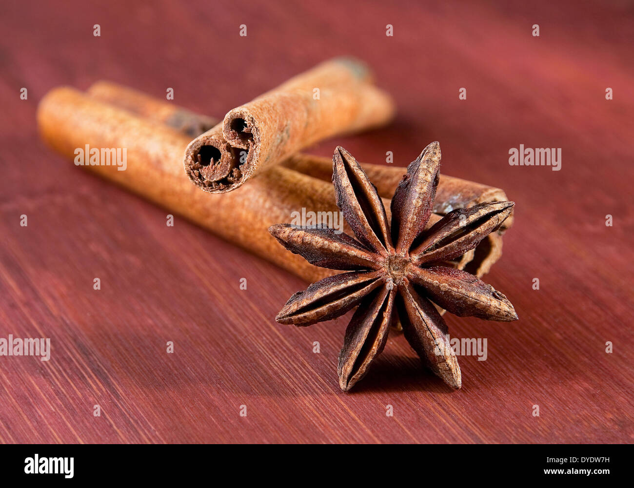 Stick of cinnamon with anise closeup on brown board Stock Photo