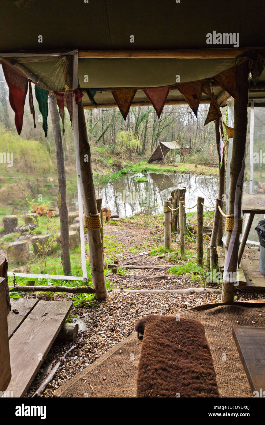 View to the lake from the communal kitchen at the glamping site Crafty Camping at Holditch, Dorset UK Stock Photo