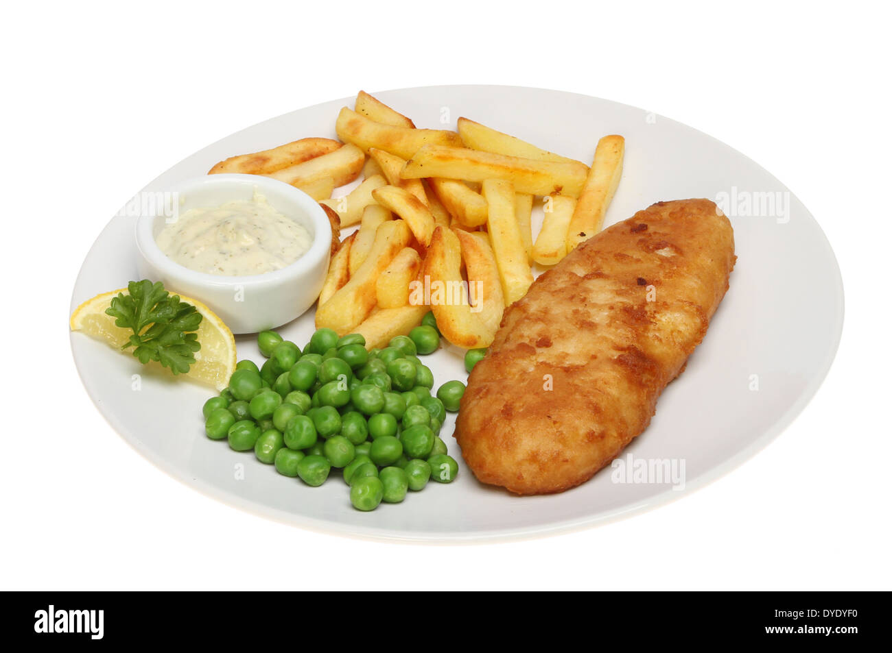 Battered fish, chips and peas with tartar sauce and a garnish of lemon and parsley on a plate isolated against white Stock Photo