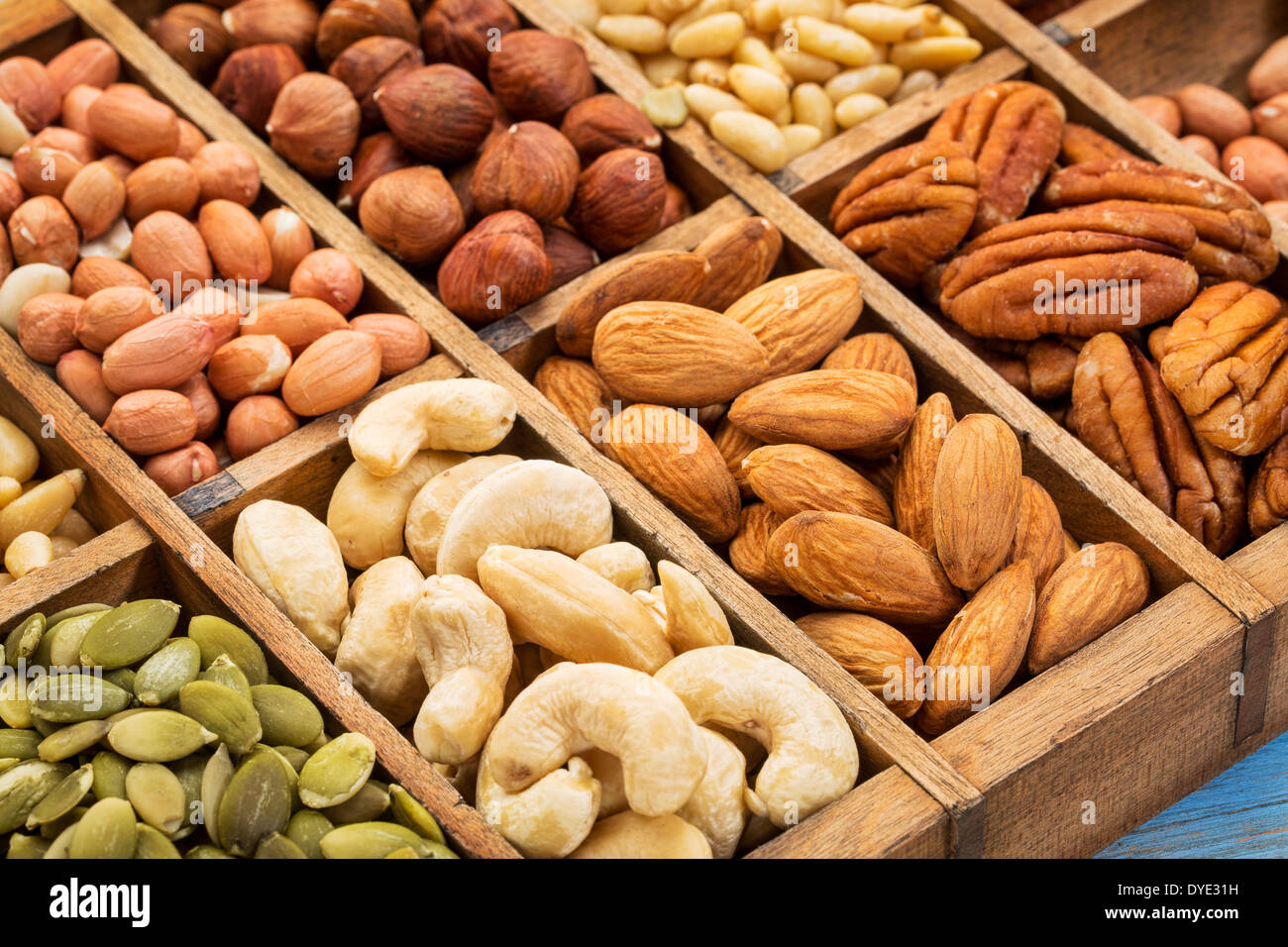 nuts and seed collection (cashew, pecan, hazelnut,pine nuts, peanut, pumpkin) in an old typesetter wooden drawer Stock Photo