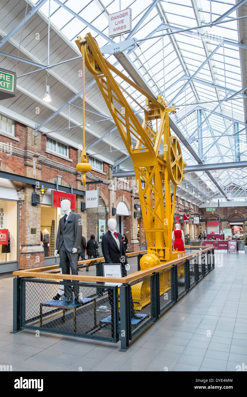 Shoppers, shops & old machinery at the converted rail works, now  McArthur Glenn designer outlet village in Swindon, Wiltshire Stock Photo