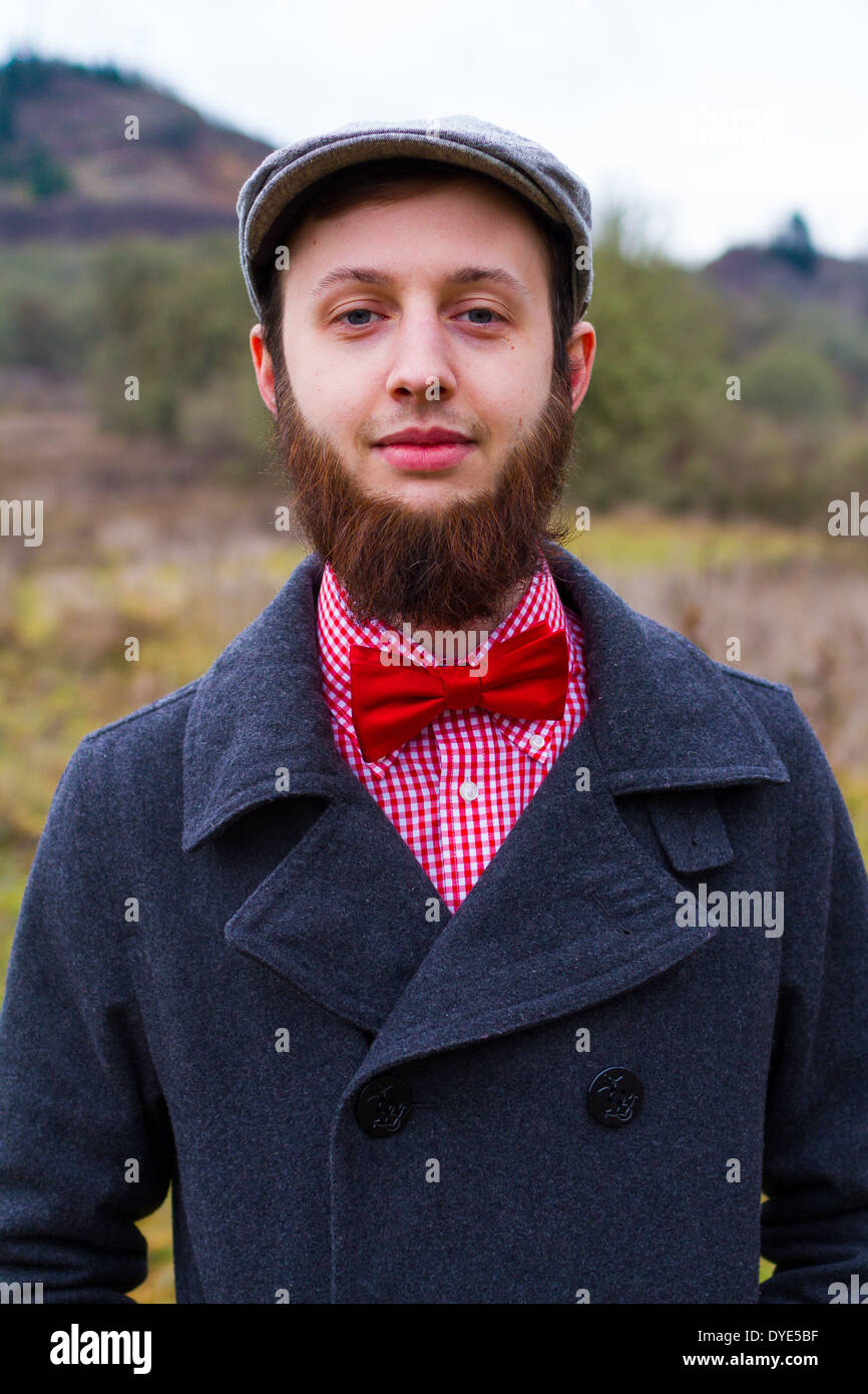 Trendy hipster guy outdoors in the winter in a fashion portrait of the handsome man. Stock Photo