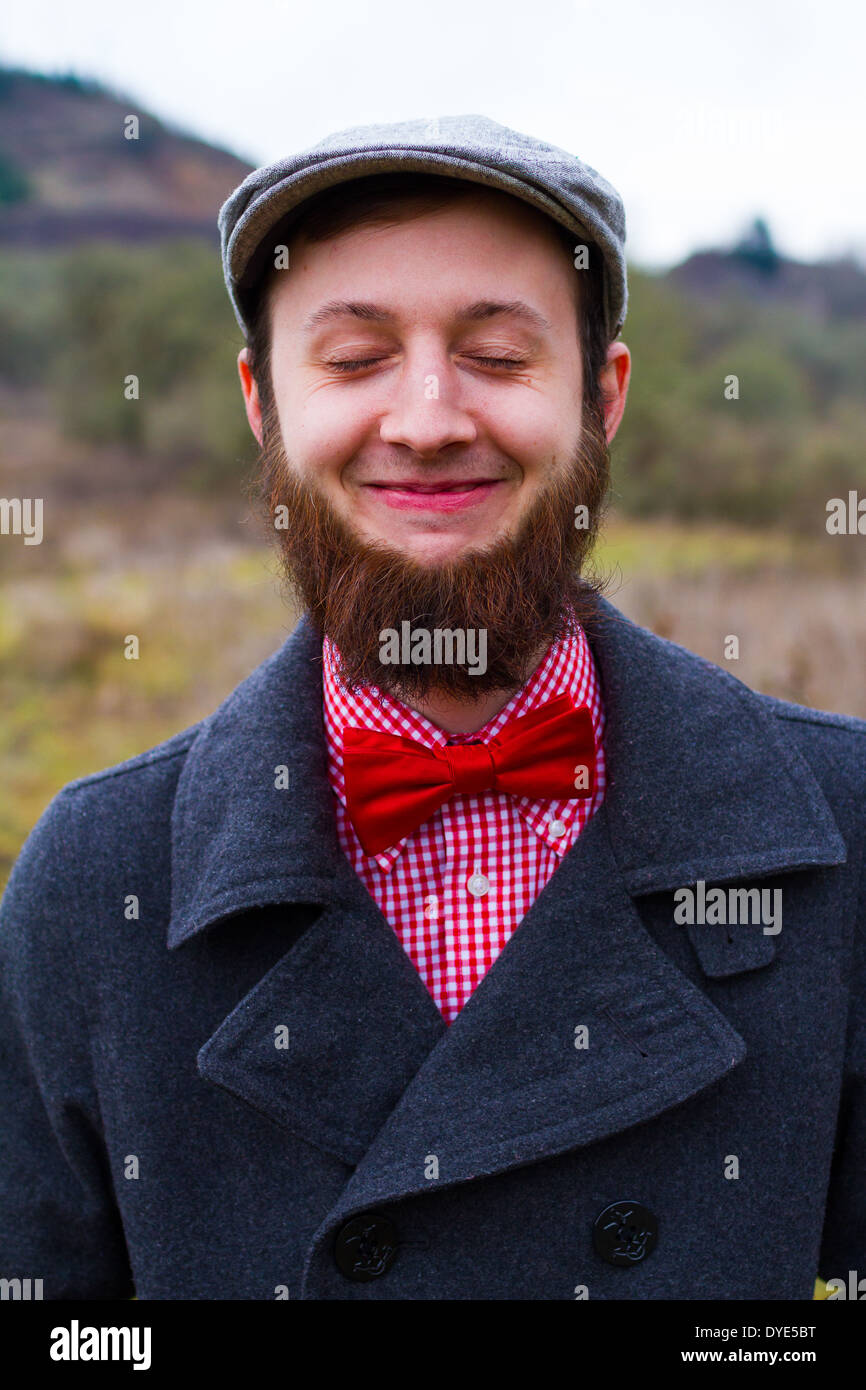 Trendy hipster guy outdoors in the winter in a fashion portrait of the handsome man. Stock Photo