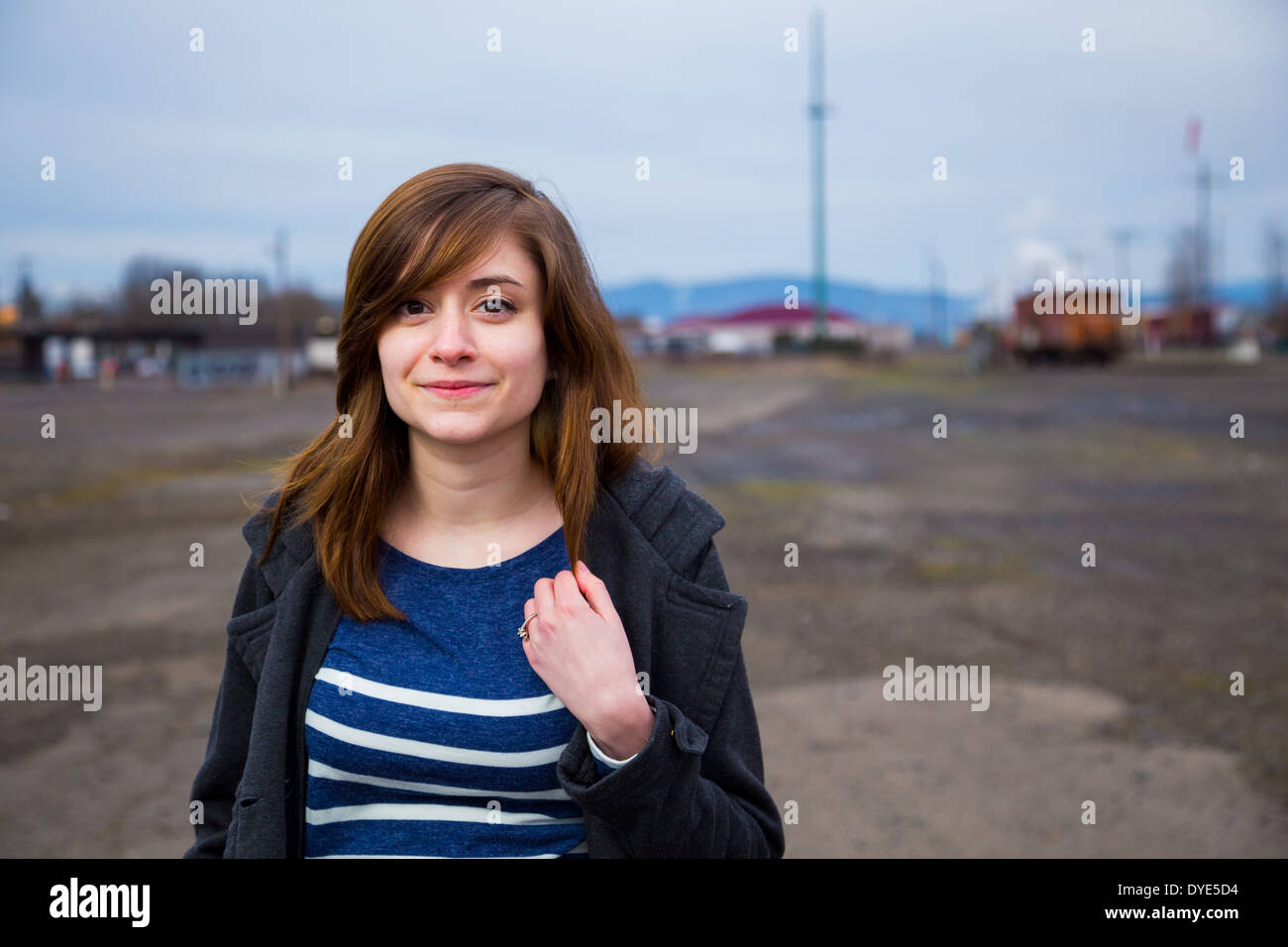 Modern, trendy, hipster girl in an abandoned train yard at dusk in this fashion style portrait. Stock Photo