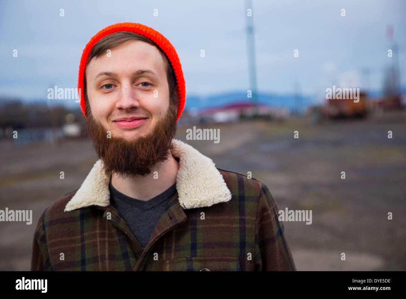 Modern, trendy, hipster guy in an abandoned train yard at dusk in this fashion style portrait. Stock Photo