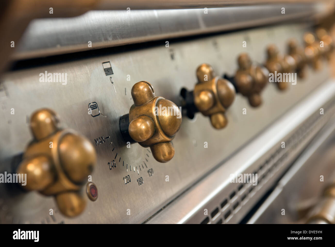 The brass knobs controlling the operation of a modern gas range cooker Stock Photo