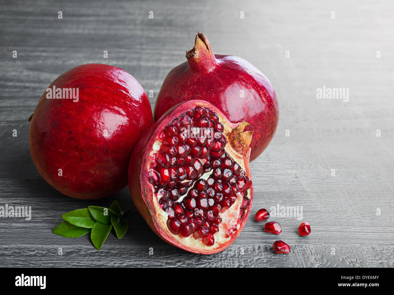 Juicy pomegranate fruit over wooden vintage table Stock Photo