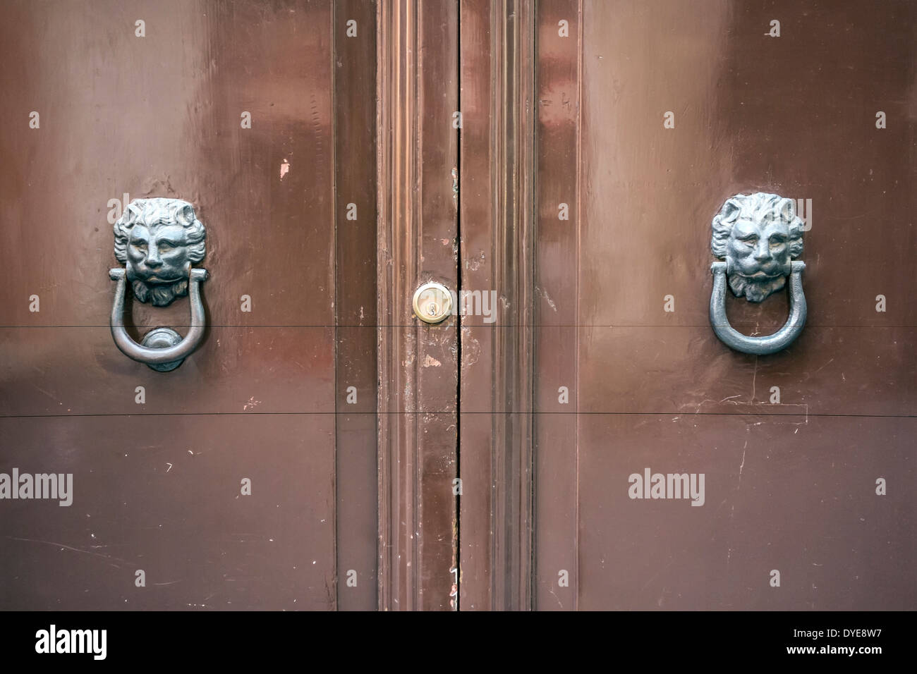 Brown wooden door with ornate lion's head door knockers in Rome, Italy Stock Photo